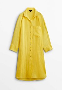 Robe chemise en lin jaune avec col, boutonnage sur le devant, manches longues et une poche poitrine. Texture lisse, coupe ample et ourlet arrondi.