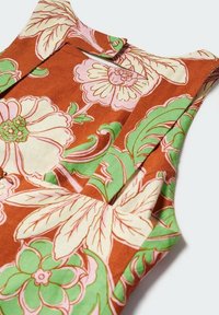 Robe sans manches à motif floral avec un fond brun audacieux, de grands motifs de fleurs roses et vertes, une texture en coton lisse et un détail de bouton.