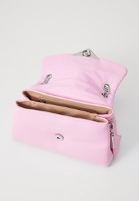 Sac à main en cuir rose avec une texture lisse, quincaillerie en argent et un fermoir supérieur. L'intérieur comporte deux compartiments et une poche zippée.