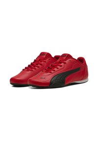 Sneaker rosse con lacci realizzate in pelle liscia con un design a contrasto nero, dotate di linguetta imbottita e suola per il massimo comfort.