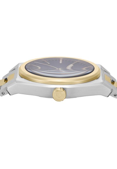 Vista laterale di un orologio da polso in argento e oro con quadrante rotondo, indici minimalisti e una corona con un logo sul lato destro.