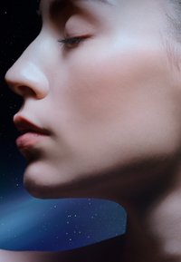 Profilvy av ett slätt, ljus hy med stängda ögon, med subtila läppar och en väldefinierad käklinje mot en mörk stjärnfull bakgrund.