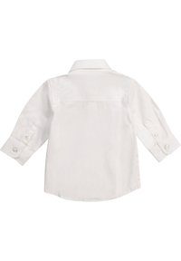 Vit långärmad skjorta med knappar och spridd krage, med knappmanschetter och rundad fåll. Tillverkad av ett mjukt, lätt tyg.