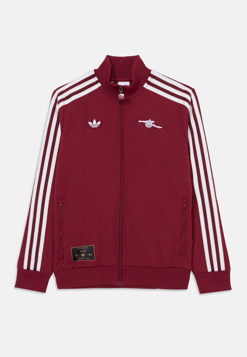 Bordová zippová bunda s vysokým golierom, biele trojpruhové akcenty, logo Adidas a emblém Arsenalu. Obsahuje bočné vrecká a ribované manžety.