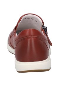 Hnědá kožená bota s kulatou zadní stranou, bílou podrážkou a nastavitelným páskem. Hladký povrch s minimálními švy.