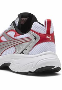 Baskets blanches avec des accents rouges et argentés, tige en mesh, collier rembourré et semelle texturée. Présente le logo PUMA sur le talon.