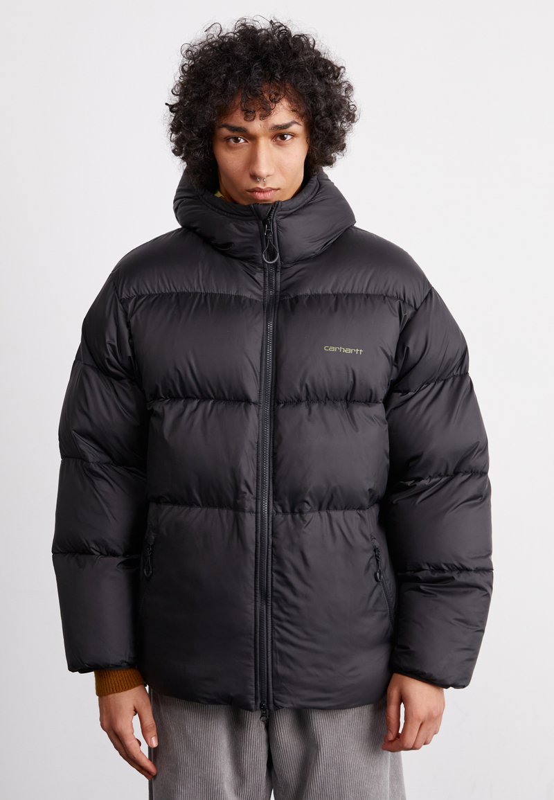 Schwarze Daunenjacke mit hohem Kragen, Reißverschluss und elastischen Bündchen. Verfügt über eine strukturierte Oberfläche und dezente Markenkennzeichnung auf der Brust.