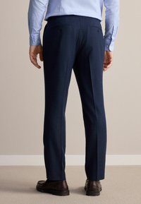 Pantalon marine ajusté, fabriqué en tissu lisse. Il dispose de deux poches arrière avec fermetures à boutons et d'une coupe droite.