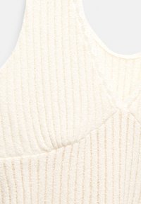 Bijela rebrasta bralette s teksturiranim materijalom; ima V-izrez i tanke naramenice. Suptilne vertikalne pruge naglašavaju dizajn.