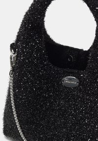Borsa nera con superficie testurizzata e scintillante. Presenta un logo metallico rotondo, tracolla a catena e manici robusti.