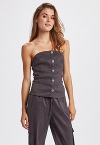 Top senza spalline di colore grigio scuro con design aderente, caratterizzato da cinque bottoni decorativi sulla parte anteriore e una texture di tessuto liscia.
