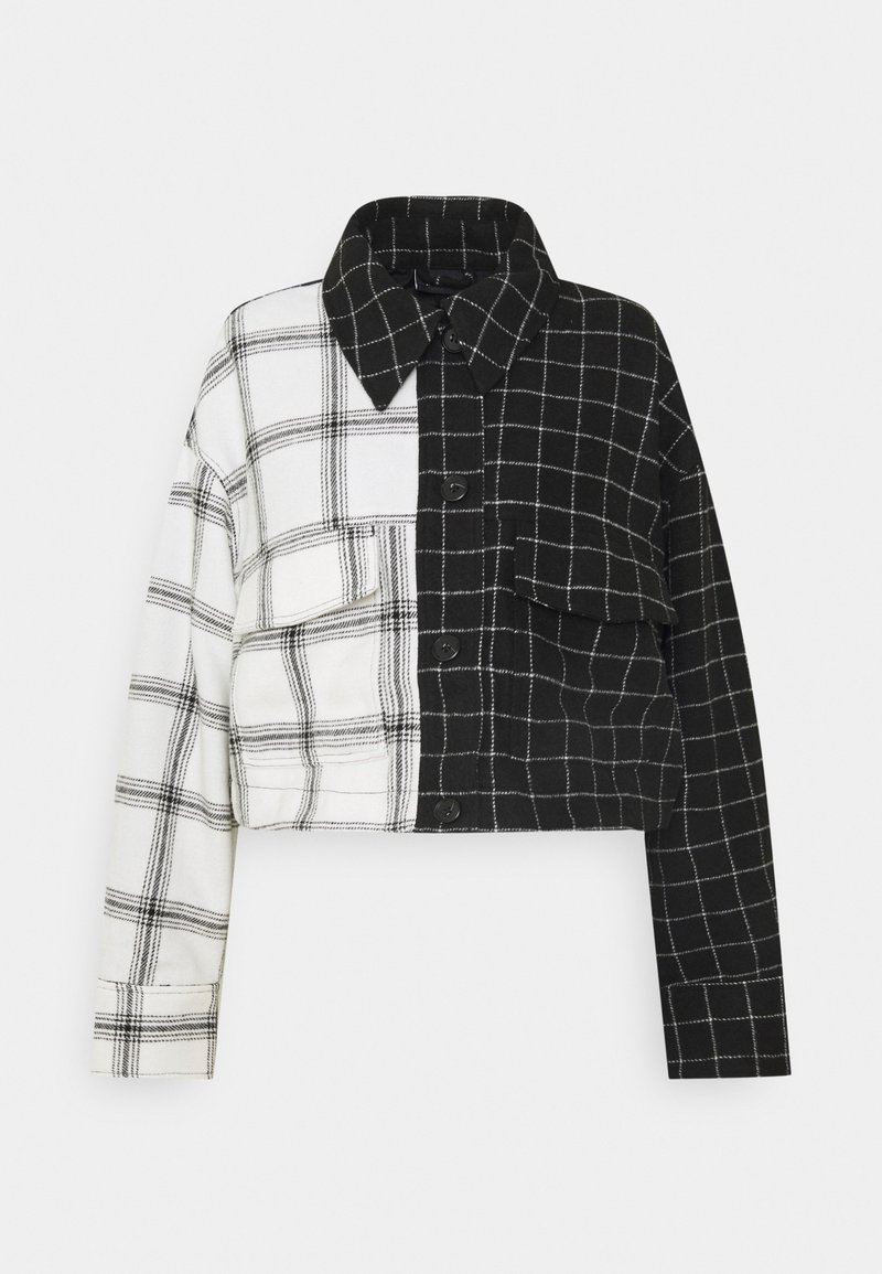 Veste courte avec un design à carreaux moitié noir, moitié blanc. Comprend un col, des boutons sur le devant, et une poche poitrine. Tissu texturé.