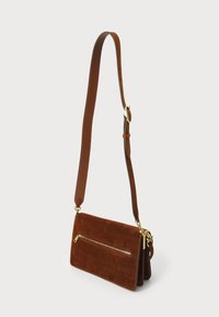 Brun ruskinds crossbody taske med en lang læderrem, der har en frontlomme med lynlås og accenter i gyldent metal. Firkantet form.