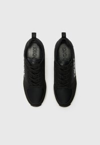 Black athletic shoes featuring a mix of smooth and textured materials, rounded toe, cushioned sole, and prominent brand logo on the side.