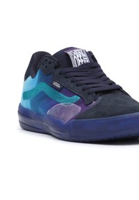 Tenisky Vans v námořnické modré a modré barevné kombinaci, vyrobené z materiálů síťoviny a semiše, s unikátními geometrickými vzory a polstrovanou černou podrážkou.