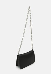 Borsa a spalla in pelle nera con tracolla a catena, forma rettangolare, superficie liscia e chiusura con zip.