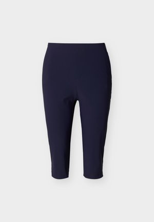 Στενά κολάν μπλε του ναυτικού μήκους μέχρι το γόνατο με ψηλή μέση και λείο υφή, παρουσιάζονται σε απλό φόντο.