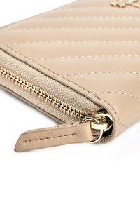 Beżowy skórzany portfel z pikowanym wzorem, złotymi akcentami i teksturowanym zamkiem błyskawicznym. Posiada odpinany pasek i gładkie wykończenie.