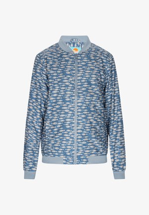 Kék bombázó dzseki, fehér halmintával. Könnyű anyagból készült, cipzáros záródással és bordás mandzsettákkal, valamint aljjal rendelkezik.