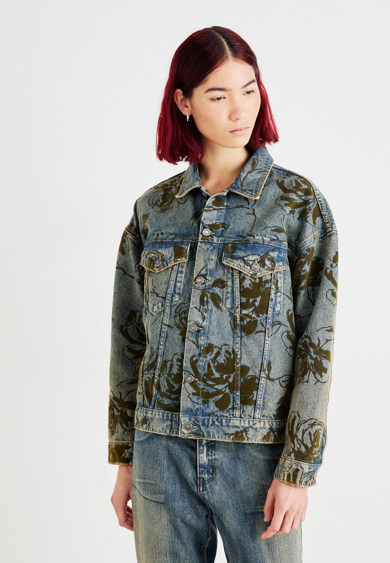 Denim jakna s cvetličnim potiskom v olivnih in modrih odtenkih. Ima klasičen dizajn, zapiranje na gumb, žepke na prsih in nekoliko ohlapen kroj.
