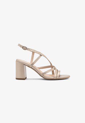 Beige hakken sandalen met meerdere kruislings banden, een blokhak en een verstelbare enkelband. Gladde leerachtige materialen.