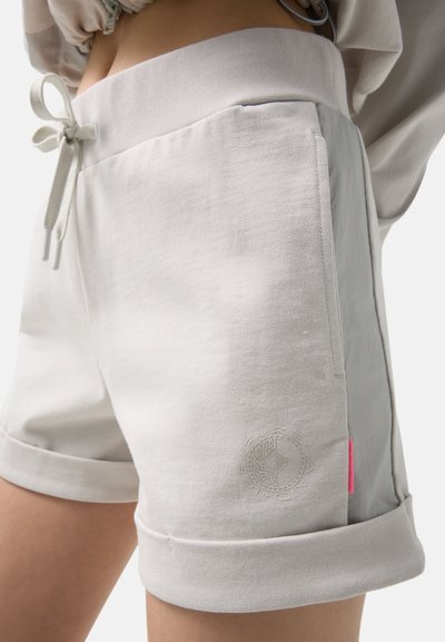 Shorts décontractés beige clair avec taille à lien de serrage, ourlets retroussés, poches latérales et logo brodé subtil sur la cuisse avant.