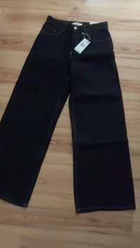 Jeans in denim nero a gamba larga con taglio dritto, dotati di chiusura a bottoni e etichetta attaccata alla vita.