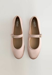 Scarpe Mary Jane di colore rosa chiaro con suola piatta. Presentano una punta arrotondata e una fibbia decorativa argentata sul cinturino. Texture liscia.