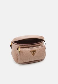 Ljusrosa quiltad väska med en guldfärgad logoplacett, dragkedja överst och sidoficka. Mjukt material och rundad form. Guldfärgade detaljer.