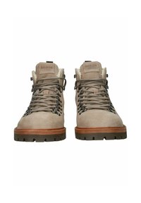 Botas de senderismo Blackstone de ante beige con suelas de goma marrones gruesas y cuellos acolchados, que cuentan con ojales en forma de gancho y cordones resistentes atados con firmeza.