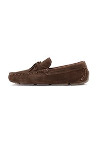 Mocasines de ante marrón con costura al estilo mocasín, suela plana y un lazo decorativo en la parte delantera. Punta redondeada y textura suave.