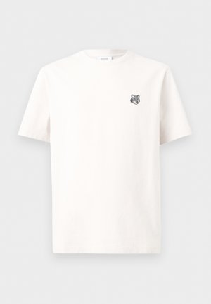 Tricou alb cu mâneci scurte și un mic logo cu capul unui lup gri pe partea stângă a pieptului, afișat pe un fundal alb simplu.