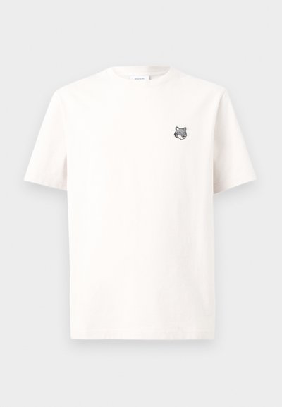 Λευκό T-shirt με κοντά μανίκια και μικρό γκρι λογότυπο κεφαλής λύκου στο αριστερό στήθος, εμφανίζεται σε απλό λευκό φόντο.