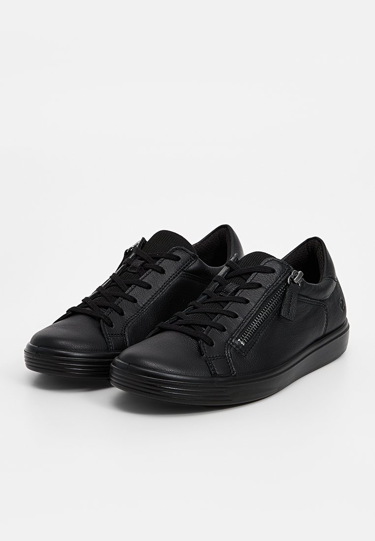 Ein Paar schwarze Leder-Sportschuhe mit schwarzen Schnürsenkeln und seitlichen Reißverschlüssen, nebeneinander auf einem weißen Hintergrund platziert.