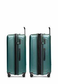 Turkooizen harde koffer met horizontale groeven, dubbele ritsen, zwarte hardware, zijhandvat en vier zwenkwielen.