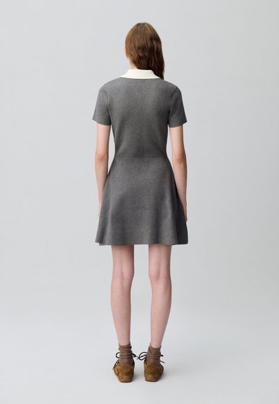 Robe grise à manches courtes avec un col blanc, corsage ajusté et jupe évasée. Présente une texture douce et un design simple.