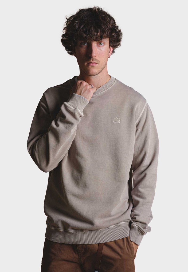 Sudadera de cuello redondo beige hecha de un tejido suave, con puños y bajo acanalados, y un pequeño logo de elefante bordado en el pecho.