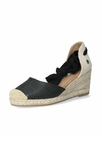 Espadrille de cuña trenzada negra con suela de yute trenzado en color marrón, que presenta un lazo de tela negra y detalles a cuadros crema en el talón.