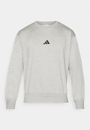 Sudadera gris hecha de una mezcla de algodón, con puños y dobladillo acanalados, y un pequeño logo negro de Adidas en el pecho. Diseño clásico de cuello redondo.