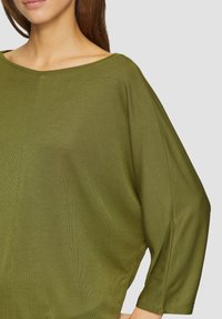 Olijf groene, oversized ribbed top met een wijde boot halslijn en driekwart mouwen, met een gladde textuur en subtiele zijnaden.