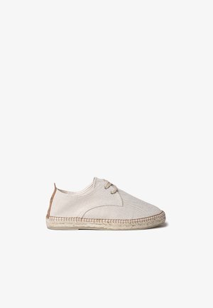 Beige canvas espadrille met ronde neus, vetersluiting aan de voorkant en een voetbed van natuurlijke jute. Leren accent bij de hak voor een extra detail.