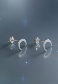 Silberne Steckerohrringe in einer Halbmärchenform mit glatter Oberfläche, ausgestattet mit einem sicheren Schmetterlingsverschluss und reflektierenden Lichtpunkten vor einem grauen Hintergrund.