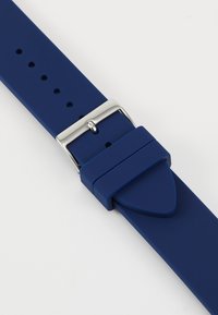 Curea de ceas din silicon albastru, cu o cataramă metalică argintie, având multiple găuri pentru ajustare și o textură mată, netedă.