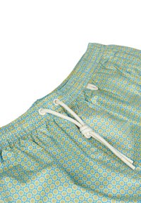 Tessuto blu con motivo a scacchi che presenta piccoli cerchi gialli, con una vita elastica e chiusure con cordoncino bianco. Texture del materiale morbida.