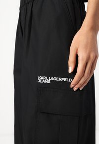 Μαύρο cargo παντελόνι από ελαφρύ ύφασμα, με κεντητό λογότυπο "KARL LAGERFELD JEANS" και λεπτομέρεια πλαϊνής τσέπης.