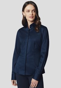 Granatowa koszula z długim rękawem, zapinana na guziki, o wyprofilowanym kroju, gładkiej fakturze i klasycznym kołnierzyku, z ukrytą listwą guzikową z przodu.