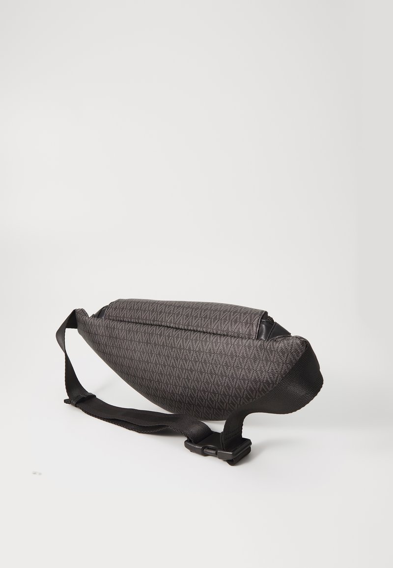 Sac en bandoulière noir texturé avec un motif en diamant, doté d'une sangle robuste et d'une forme épurée, adapté à un usage décontracté.