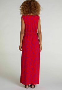 Robe maxi rouge à motif floral, sans manches, avec une taille élastique. Fabriquée dans un tissu léger avec une texture lisse.