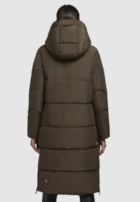 Cappotto imbottito lungo di colore verde oliva con cappuccio arricciato, motivo a cucitura orizzontale e cerniere laterali. Presenta una patch con logo vicino all'orlo.