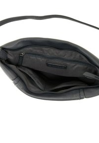 Interior de un bolso de mano de cuero gris oscuro con un acabado texturizado, que presenta un compartimento con cremallera y bolsillos adicionales abiertos.